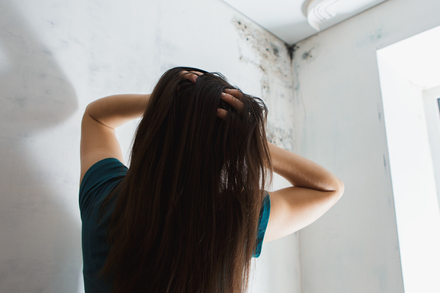 Image of Women looking at wall in need of Mold Remediator services